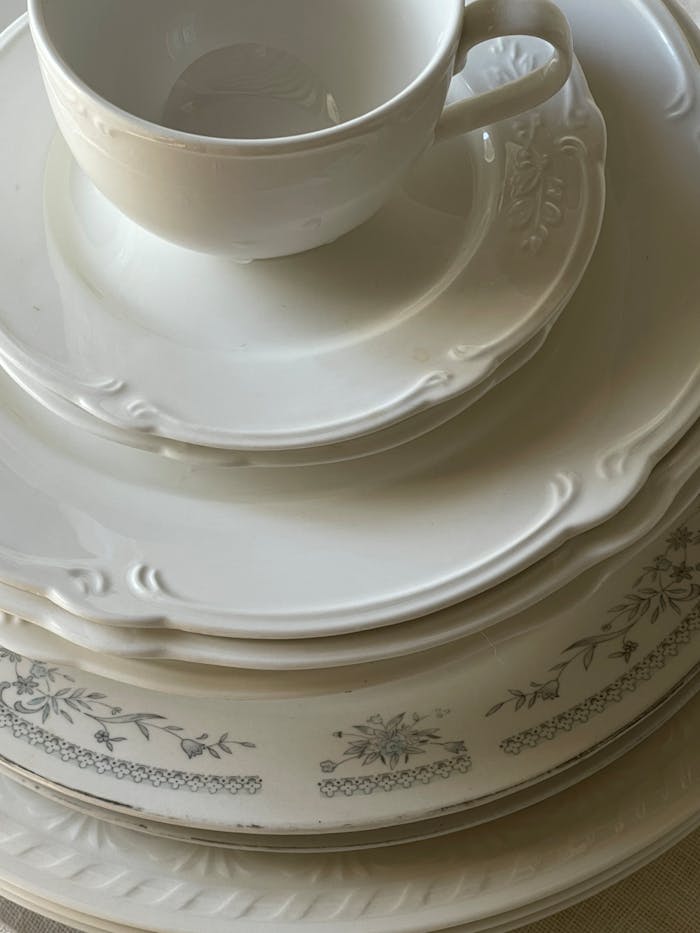 A close-up of elegant white porcelain tableware arranged in a stack, showcasing intricate design.